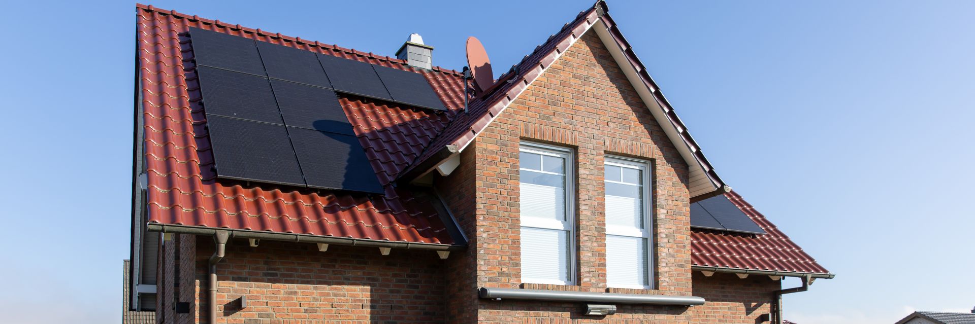Die Ansicht eines Hauses mit einer Photovoltaik-Anlage auf dem Dach.