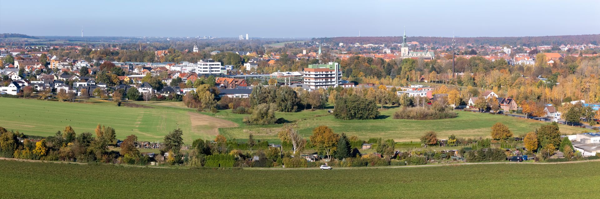 Eine Ansicht auf die Stadt Wolfenbüttel. Weiter hinten ist eine Kirche zu sehen. Im Vordergrund sind Kleingärten zu erkennen.