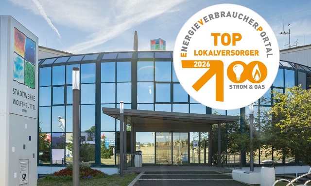 Außenansicht des Eingangsbereichs des Stadtwerke Gebäudes bei strahlendem Sonnenschein. Siegel TOP Lokalversorger 2026.